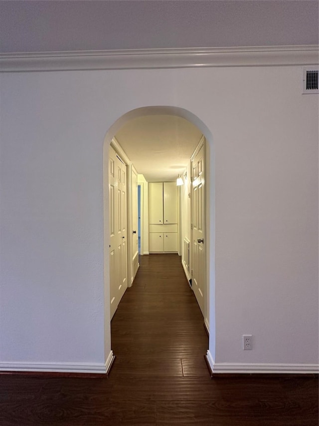 hallway featuring dark hardwood / wood-style floors and crown molding