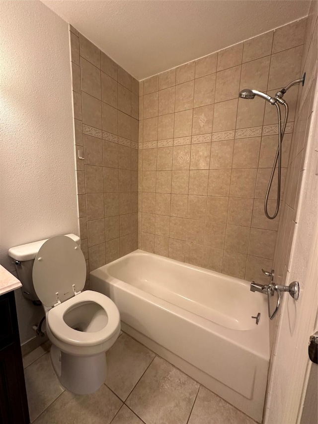 full bathroom featuring a textured ceiling, vanity, tiled shower / bath combo, tile patterned flooring, and toilet