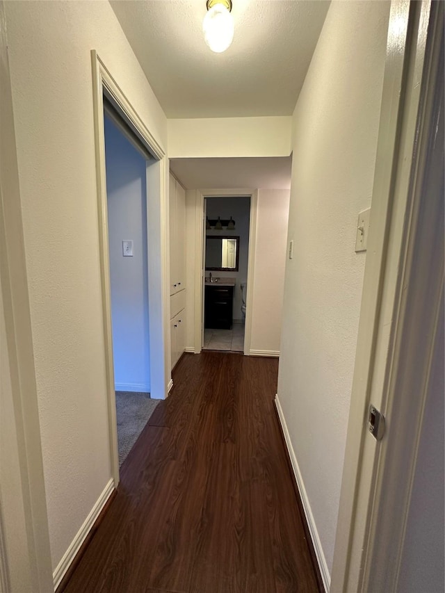 corridor with dark hardwood / wood-style flooring