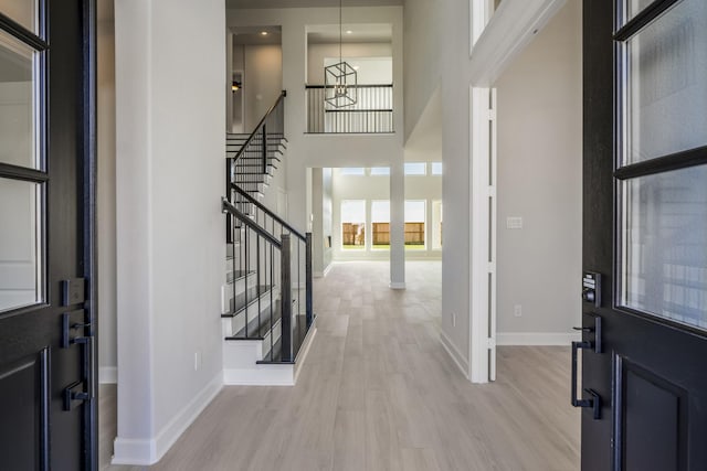 foyer with a high ceiling and light hardwood / wood-style floors