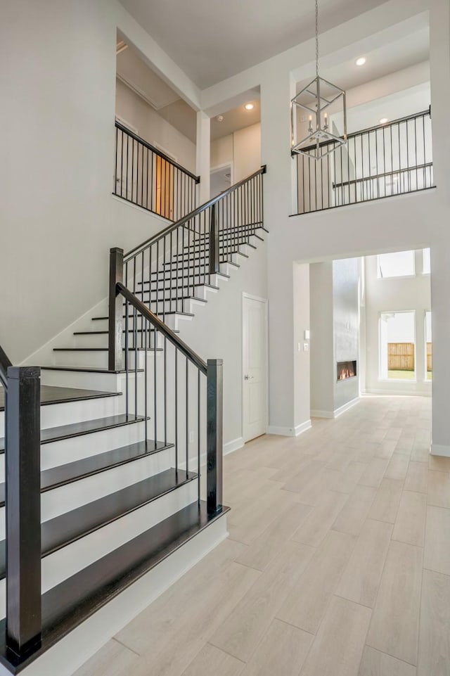 stairway with a towering ceiling and a chandelier