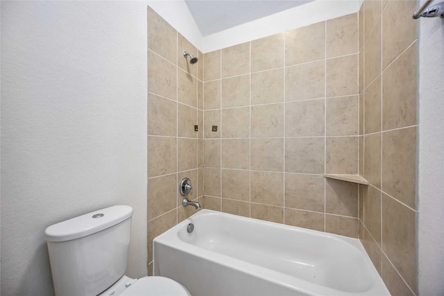 bathroom with toilet and tiled shower / bath