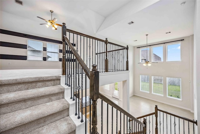 stairs featuring ceiling fan