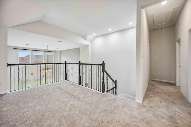 corridor with lofted ceiling and light colored carpet