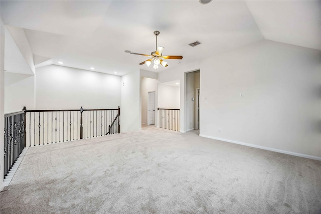 carpeted spare room featuring ceiling fan and vaulted ceiling