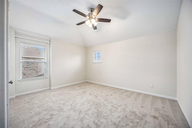 spare room featuring ceiling fan, light colored carpet, a wealth of natural light, and lofted ceiling