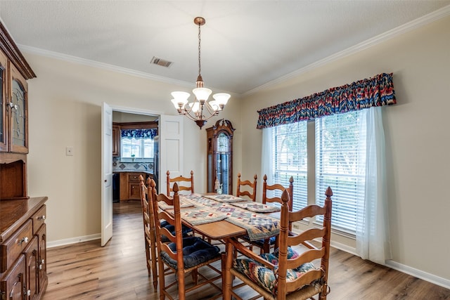 12135 Oakcroft Dr, Houston, TX 77070 - dining space with baseboards, visible vents, an inviting chandelier, light wood-style floors, and ornamental molding