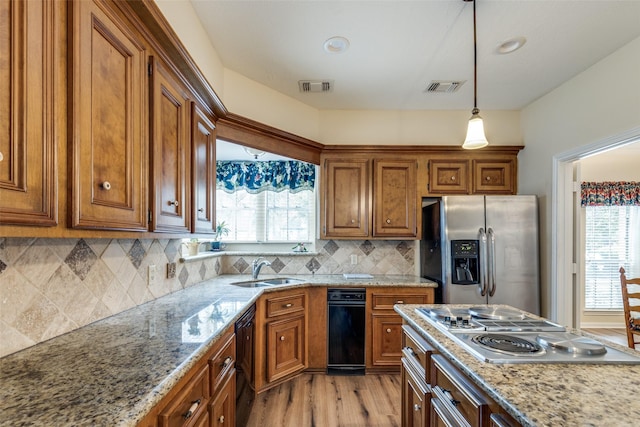 12135 Oakcroft Dr, Houston, TX 77070 - kitchen with brown cabinets, appliances with stainless steel finishes, pendant lighting, and visible vents