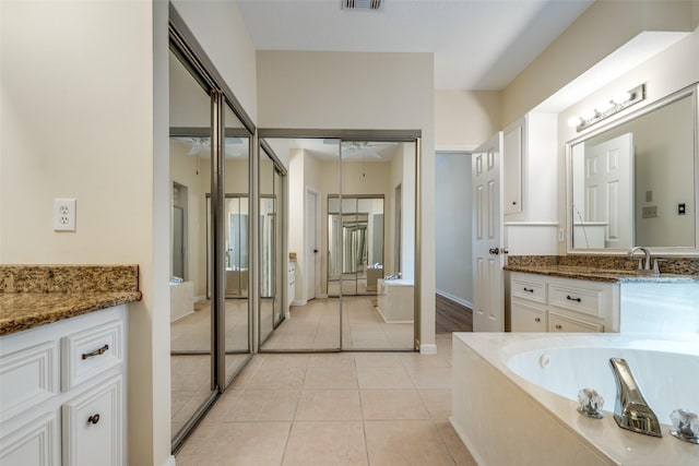 bathroom featuring vanity, a tub to relax in, tile patterned floors, and ceiling fan