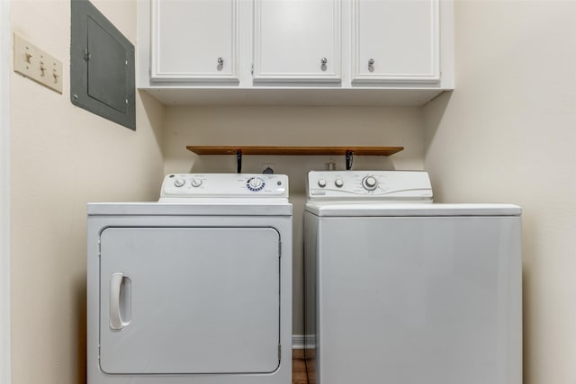 laundry room with washer and dryer, electric panel, and cabinets