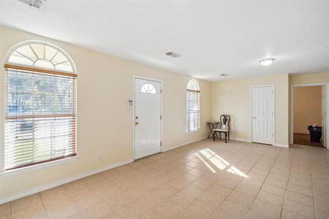 tiled entrance foyer with a healthy amount of sunlight