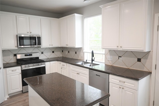 kitchen featuring white cabinets, decorative backsplash, stainless steel appliances, and sink