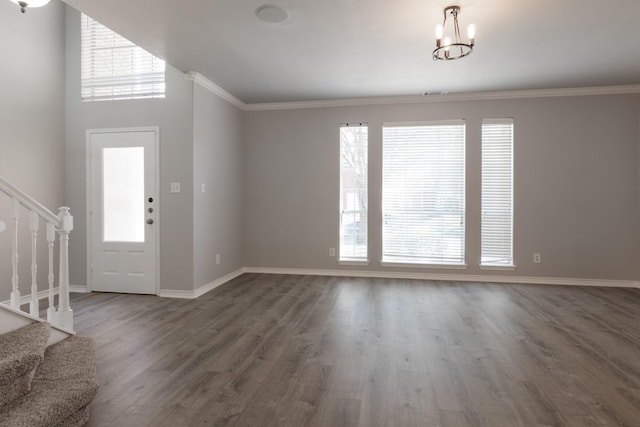 foyer featuring dark wood-type flooring, ornamental molding, and a healthy amount of sunlight