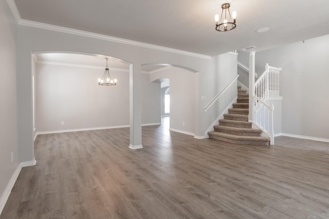 unfurnished living room with crown molding, wood-type flooring, and a chandelier