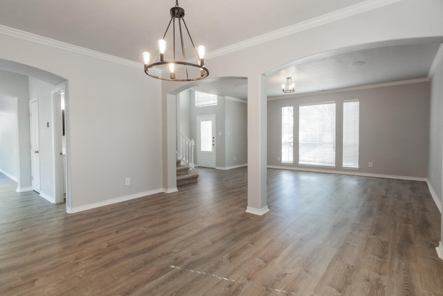 empty room featuring an inviting chandelier, crown molding, and hardwood / wood-style flooring