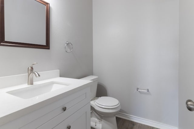 bathroom with vanity, hardwood / wood-style floors, and toilet