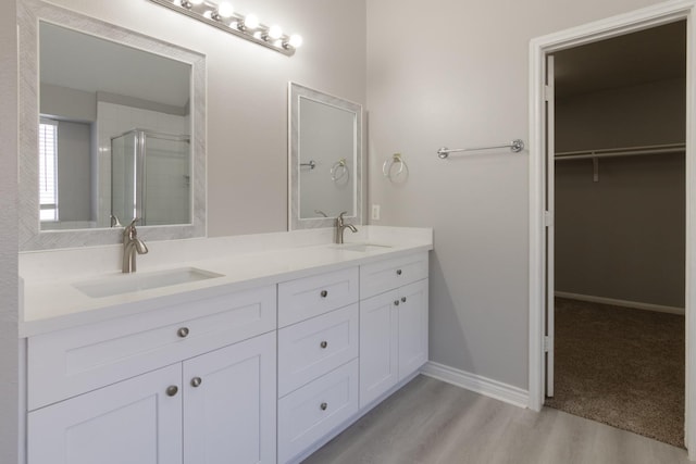 bathroom with vanity, hardwood / wood-style floors, and a shower with shower door