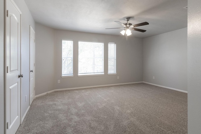 carpeted spare room with ceiling fan