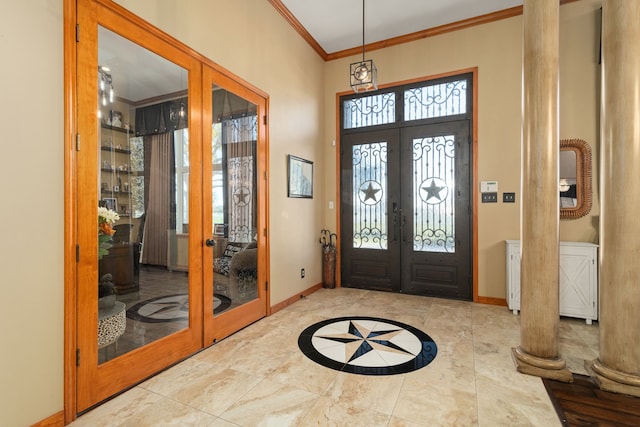 foyer with ornate columns, crown molding, and french doors