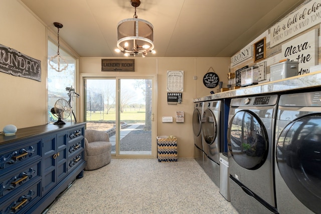 clothes washing area featuring separate washer and dryer and a notable chandelier