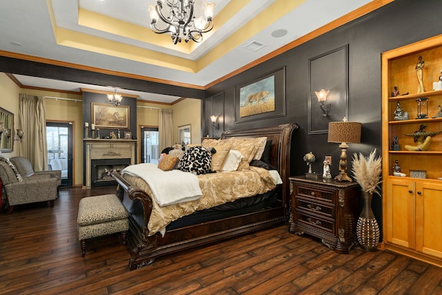 bedroom with dark hardwood / wood-style floors, crown molding, a chandelier, and a tray ceiling