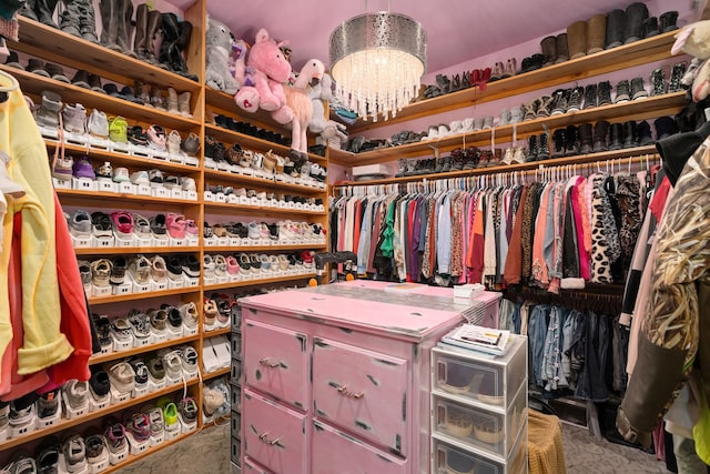 walk in closet with a chandelier