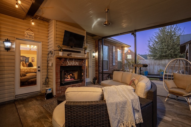 sunroom featuring beam ceiling, an outdoor brick fireplace, and wooden ceiling