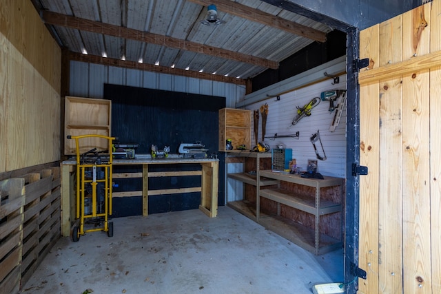 garage with a workshop area and wooden walls