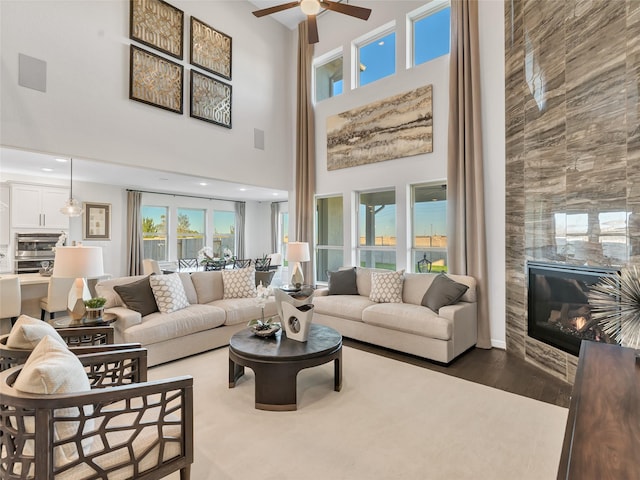 1412 River Point Dr, Friendswood, TX 77546 - living area featuring a ceiling fan, a high ceiling, wood finished floors, healthy amount of natural light, and a high end fireplace