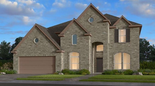 french provincial home with a garage, brick siding, and driveway