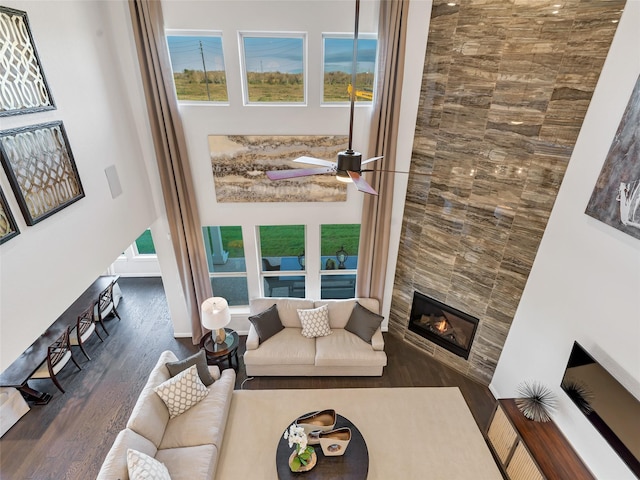 1412 River Point Dr, Friendswood, TX 77546 - living room with wood finished floors, a tiled fireplace, a towering ceiling, and a ceiling fan