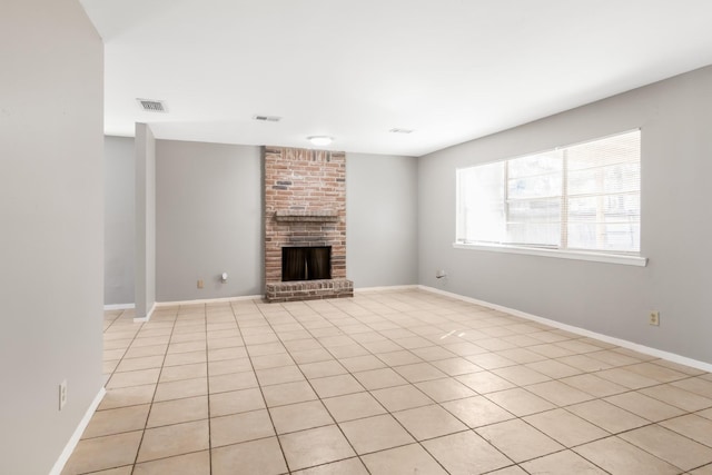 unfurnished living room with light tile patterned floors and a brick fireplace