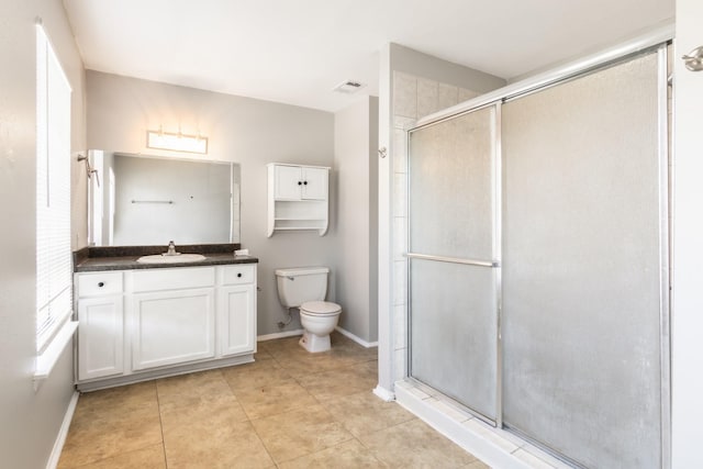 bathroom with tile patterned flooring, vanity, an enclosed shower, and toilet