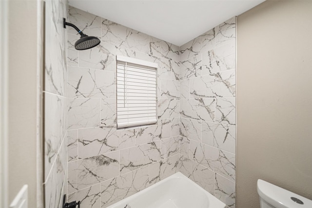 bathroom featuring toilet and tiled shower / bath