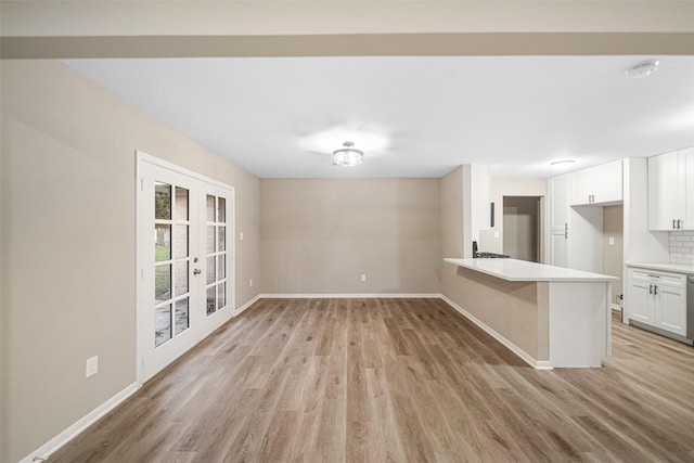 kitchen featuring backsplash, white cabinetry, french doors, and light hardwood / wood-style flooring