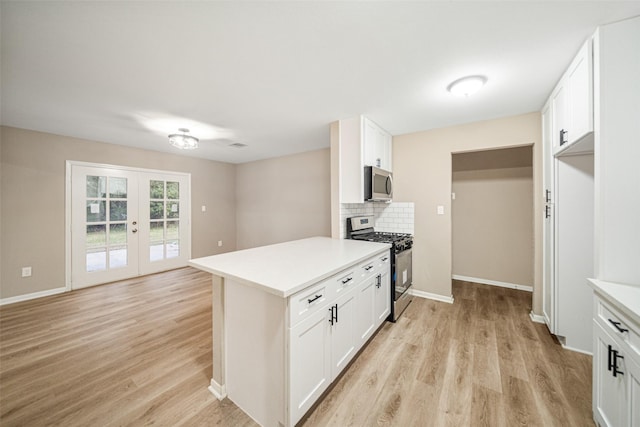 kitchen featuring backsplash, french doors, white cabinets, light wood-type flooring, and appliances with stainless steel finishes