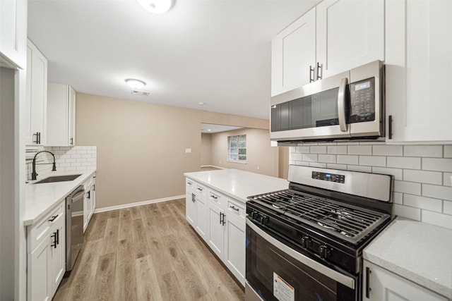 kitchen featuring backsplash, stainless steel appliances, white cabinetry, and sink