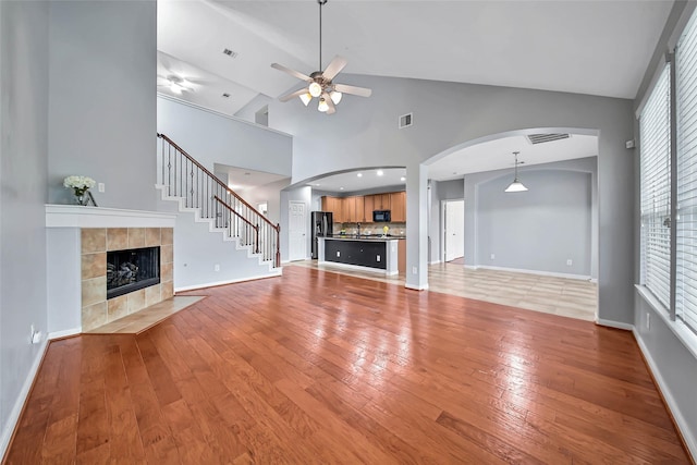 unfurnished living room with a fireplace, visible vents, and wood finished floors