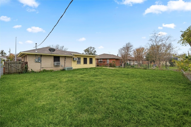 rear view of house with a lawn and cooling unit