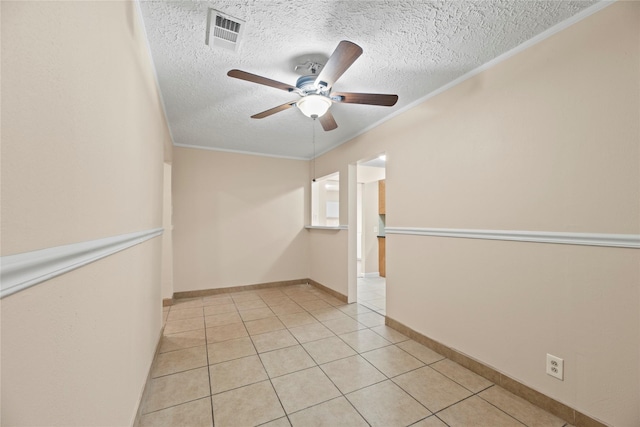 tiled spare room with a textured ceiling, ceiling fan, and ornamental molding