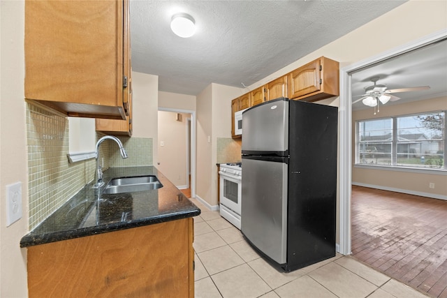 kitchen featuring backsplash, white appliances, sink, and light tile patterned floors