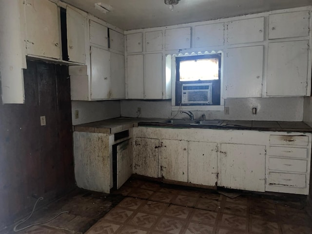 kitchen with cooling unit, sink, and white cabinets