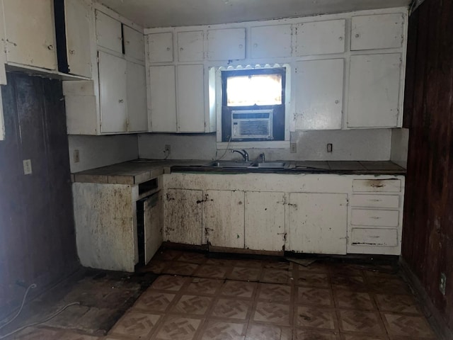 kitchen with dark parquet flooring, sink, and white cabinets