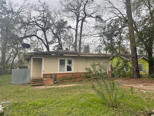 view of front of house with brick siding, fence, and a front lawn