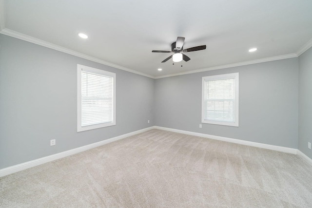 empty room featuring ceiling fan, light colored carpet, and crown molding