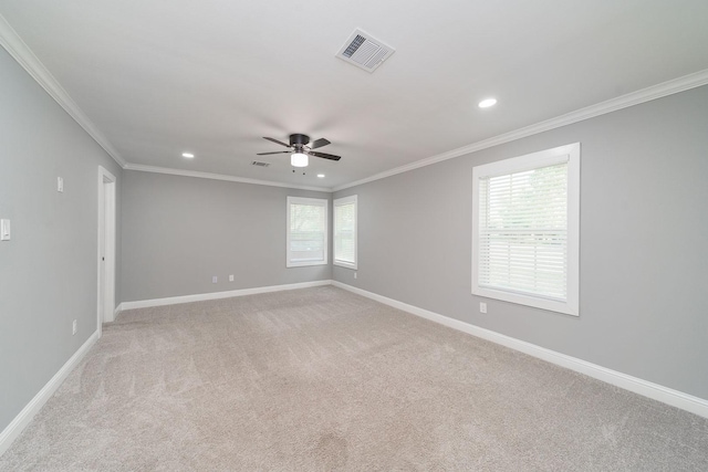 empty room featuring ceiling fan, light colored carpet, and ornamental molding