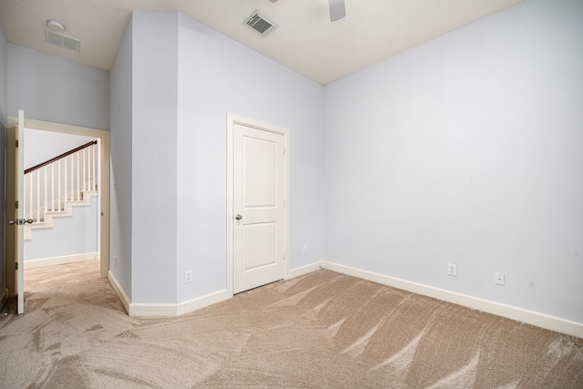 unfurnished room featuring light carpet and ceiling fan