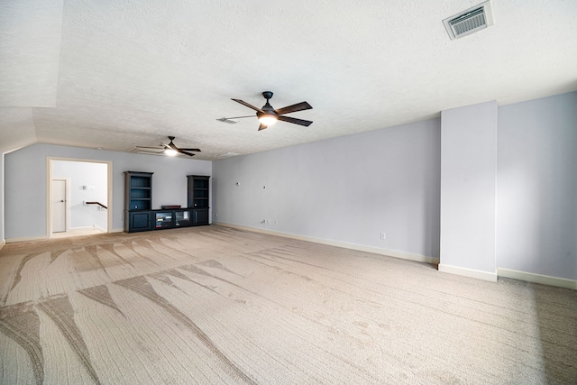 unfurnished living room featuring carpet flooring, a textured ceiling, ceiling fan, and lofted ceiling