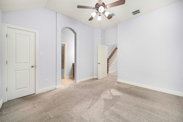 carpeted empty room with vaulted ceiling and ceiling fan