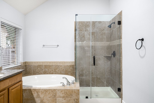 bathroom featuring plus walk in shower, vanity, and lofted ceiling